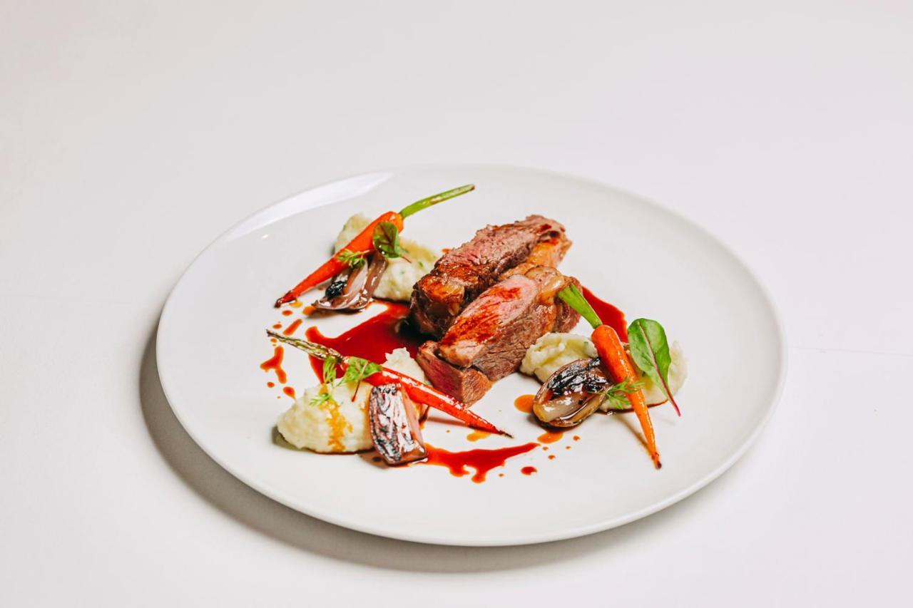 Ap Lago Montargil - Conference & Spa Exterior foto The photo features a beautifully plated dish. At the center, there are slices of a tender meat, likely beef, showcasing a juicy pink interior. Accompanying the meat are several elements: vibrant orange carrots, perhaps roasted or glazed, and dollops 