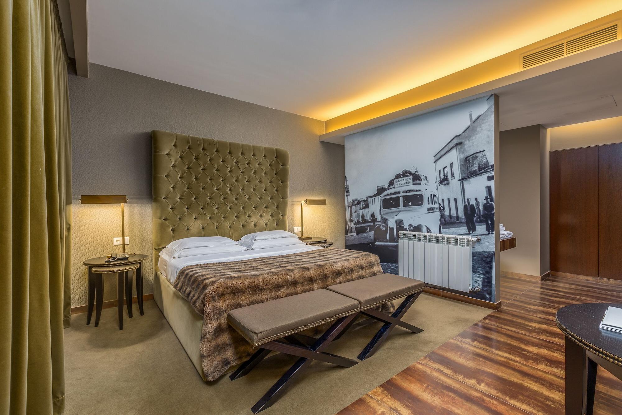 Ap Lago Montargil - Conference & Spa Exterior foto The photo shows a modern hotel room featuring a king-sized bed with a tufted headboard, dressed in white linens and a decorative throw blanket. On either side of the bed, there are bedside tables with lamps. The room is well-lit, with an ambient ceil